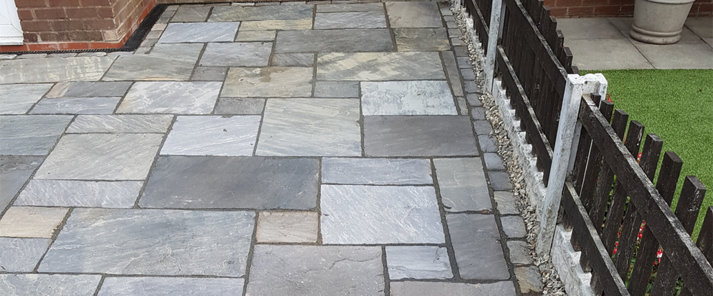 Farmhouse Premium Indian Sandstone driveway from an alternate angle, showcasing its deep charcoal tones, aged surface, and hand-worn edges for a heritage-style finish