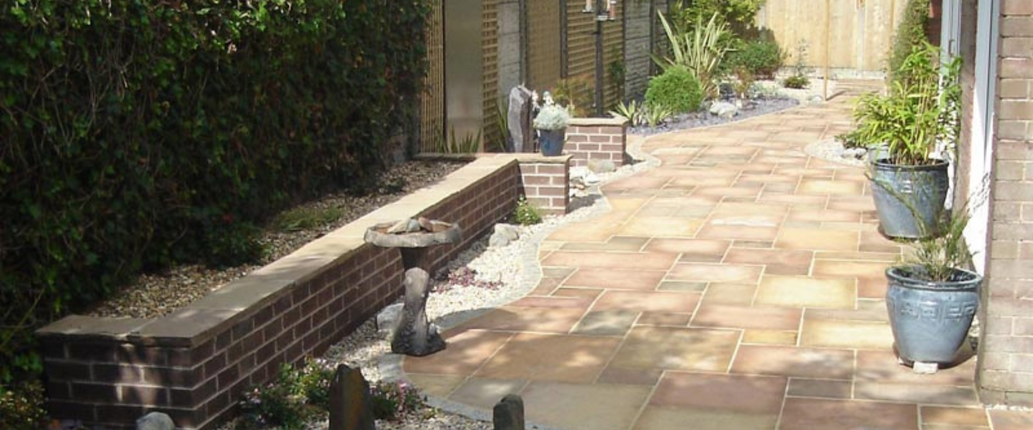 Golden Leaf Indian Sandstone paving slabs with a natural riven surface and hand-cut edges, featuring warm golden, amber, and buff tones