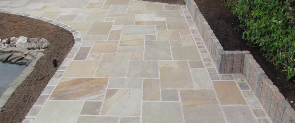Golden Leaf Indian Sandstone paving slabs with a hand-cut finish and natural riven texture, featuring warm golden, beige, and ochre tones for a rustic outdoor feel