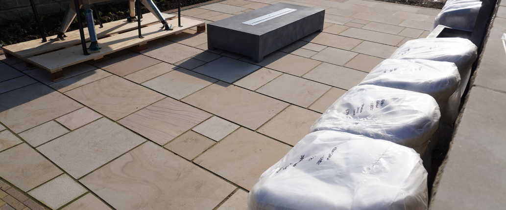 Golden Leaf Sawn Indian Sandstone patio with a smooth honed finish, featuring warm golden and beige tones in a stylish outdoor seating area