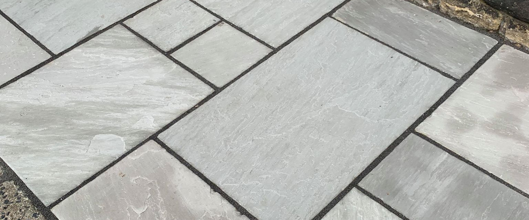 Kandla Grey Indian Sandstone slabs stacked, displaying mixed-size options with natural grey tones and hand-cut edges