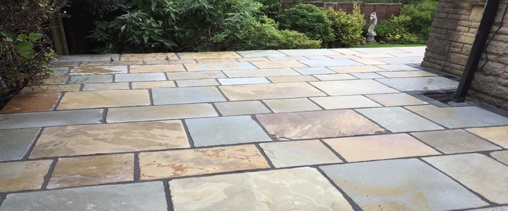 Old Courtyard Limestone patio with a timeworn, aged finish, featuring sage, honey, and grey tones for a heritage-inspired outdoor space.