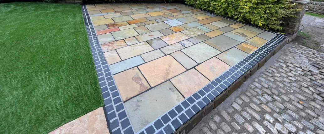 Cosy outdoor seating area with Old Courtyard Limestone paving, highlighting its aged, reclaimed look and warm natural tones.