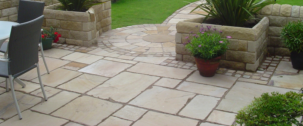 Whitby Indian Sandstone paving in an outdoor seating area, showcasing its pale buff and warm orange tones with a naturally riven surface
